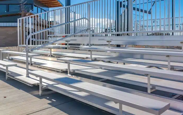 Annual bleacher inspection in Connecticut gymnasium showing structural safety checks of seating, railings, stairs, and support systems for compliance
