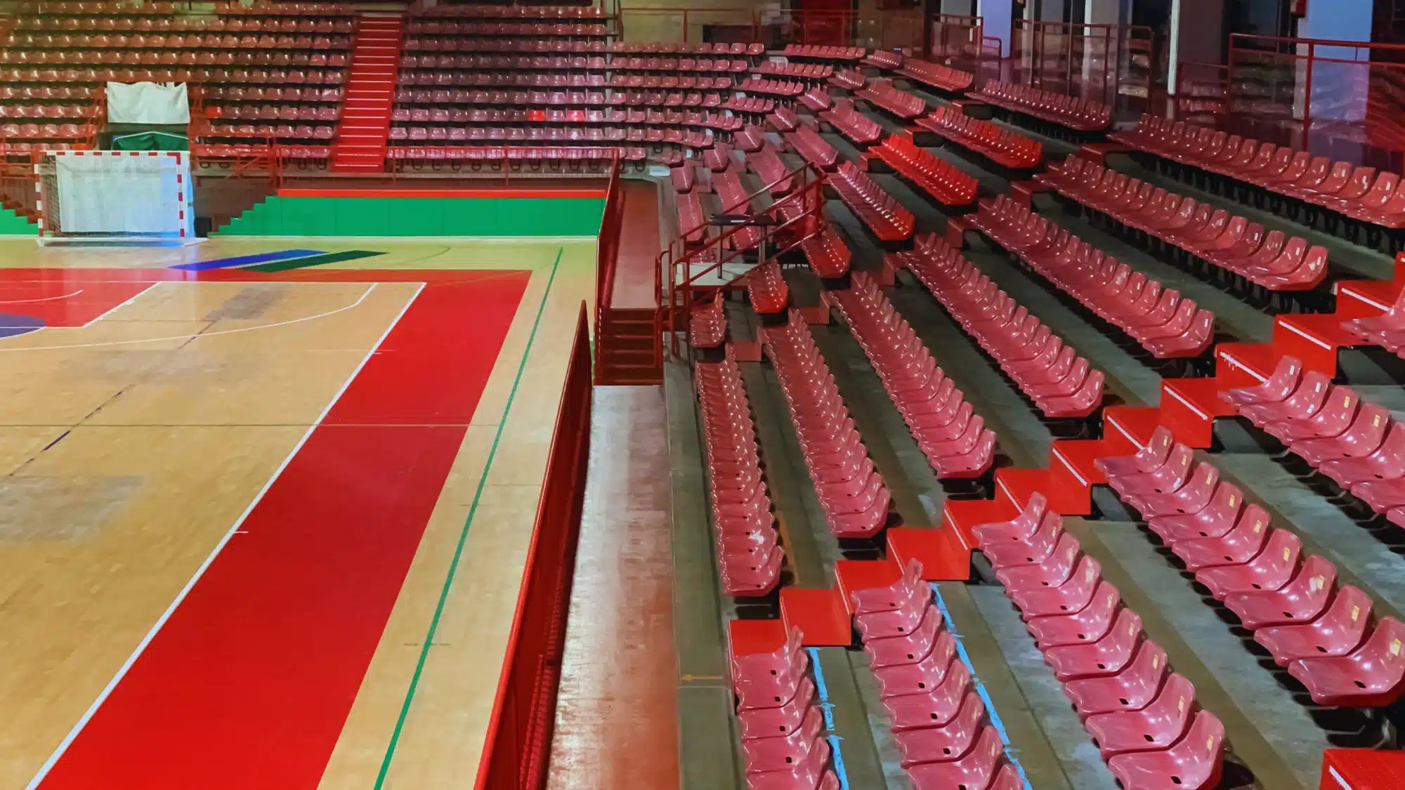 Bleacher inspection company examining gymnasium seating structure including bolts, railings, stairs, and load-bearing supports before public use approval