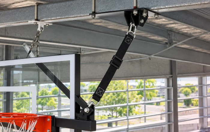 Basketball hoop safety straps being inspected for secure gym use