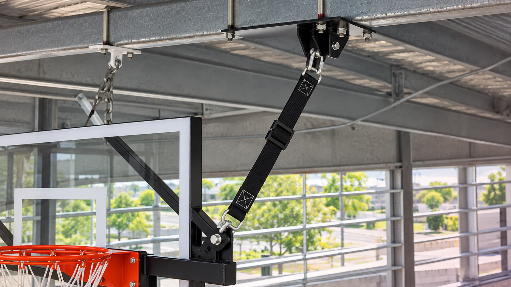 Basketball hoop safety straps being inspected for secure gym use