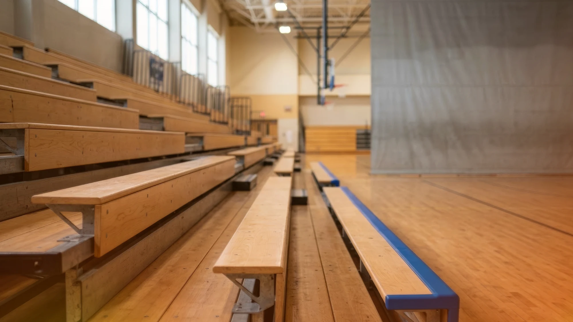 A professional team installing bleachers in a school gymnasium